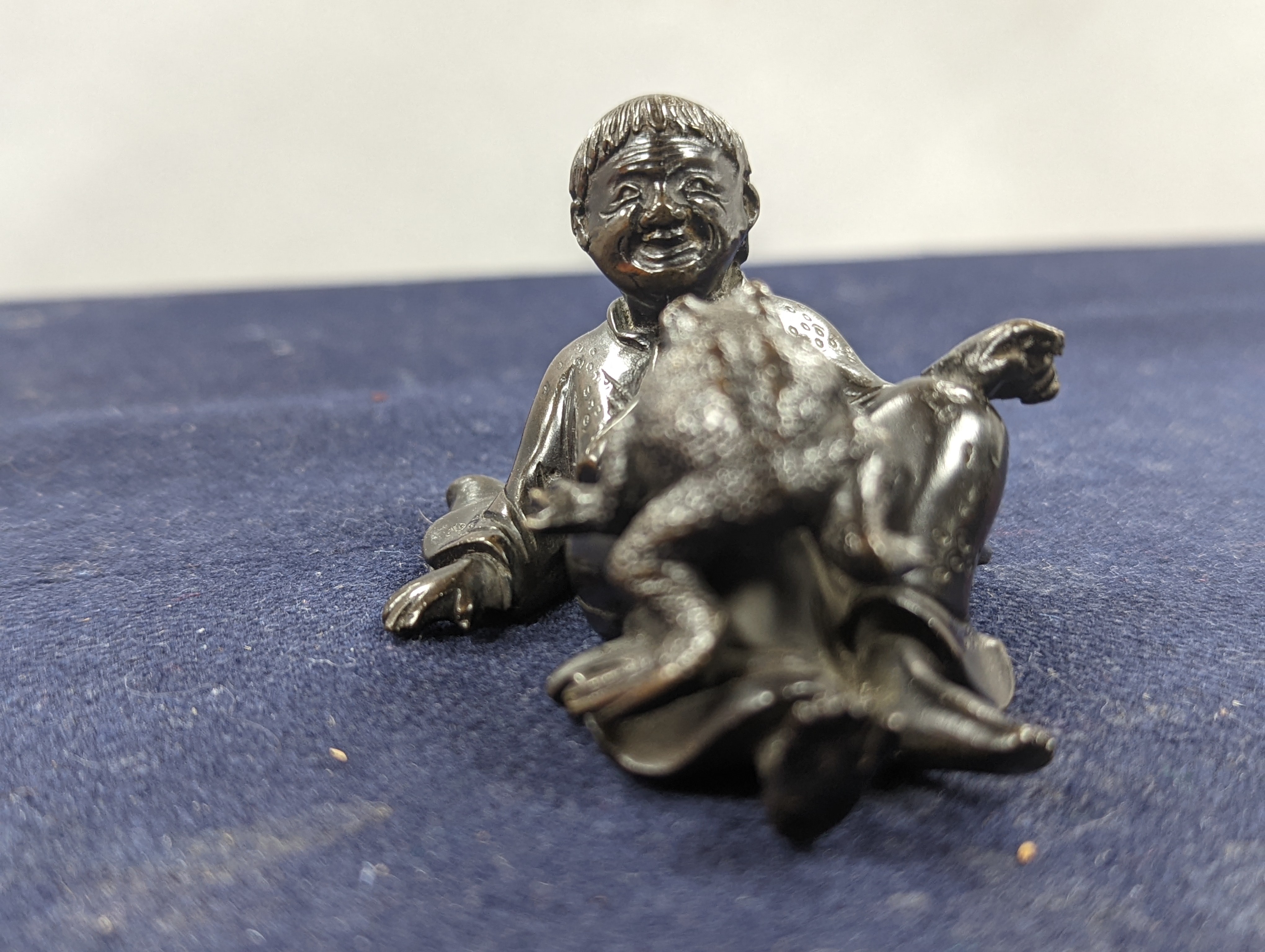A Chinese bronze group of Liu Hai and a toad, wood stand and a bronze figure of a dog, 9cm